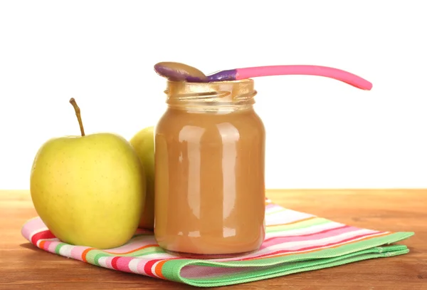 Jar met apple, babyvoedsel, lepel en appels op kleurrijke servet op witte achtergrond close-up — Stockfoto