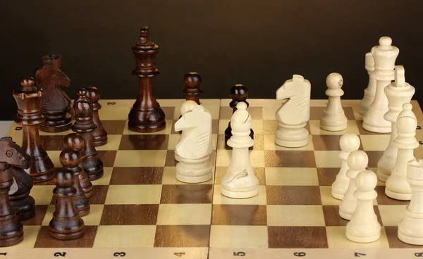 茶色の背景にチェスの駒でチェス盤 — ストック写真