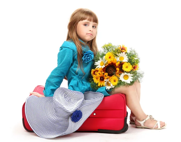 Portrait of little girl on travel case with bouquet and hat isolated on white — Stock Photo, Image
