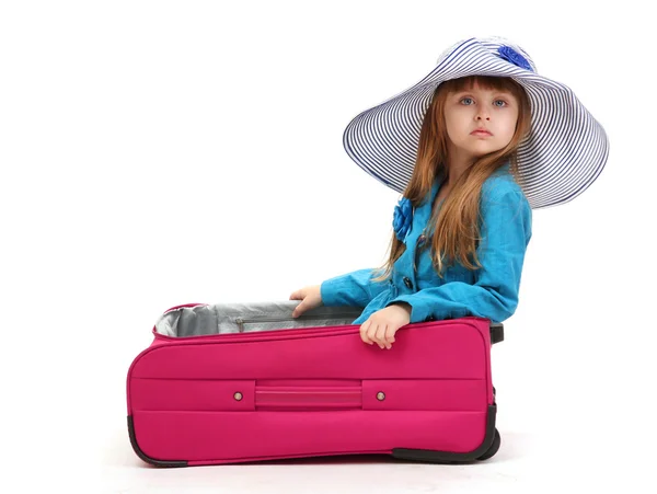 Portrait of little girl in travel case with hat isolated on white — Stock Photo, Image