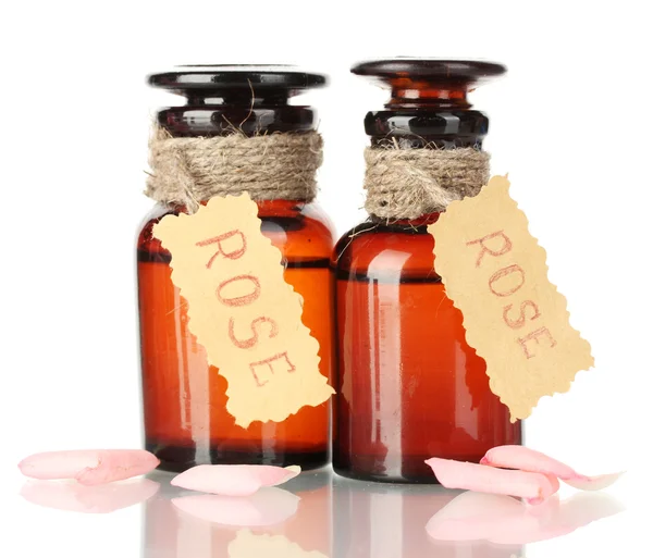 Bottles of oil and rose petals isolated on white — Stock Photo, Image