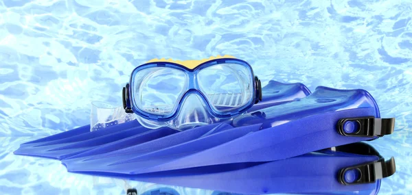 Blue flippers and mask on blue sea background — Stock Photo, Image