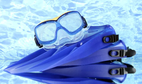 Nadadeiras azuis e máscara no fundo do mar azul — Fotografia de Stock