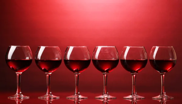 Weingläser auf rotem Hintergrund — Stockfoto
