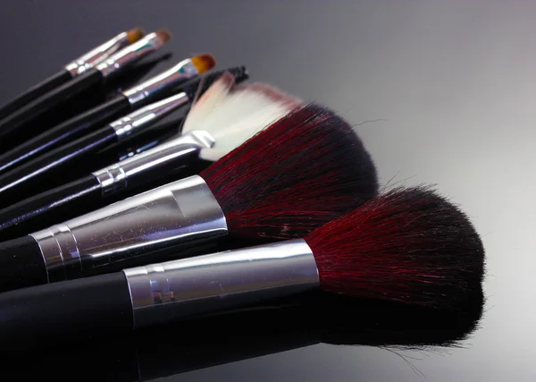 Pinceles de maquillaje sobre fondo gris — Foto de Stock