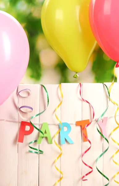 Party. Luftballons gegen einen Holzzaun auf grünem Hintergrund — Stockfoto