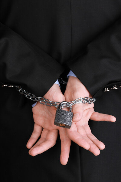 Businessman hands fettered with chain and padlock