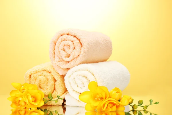 stock image Colorful towels and flowers on yellow background