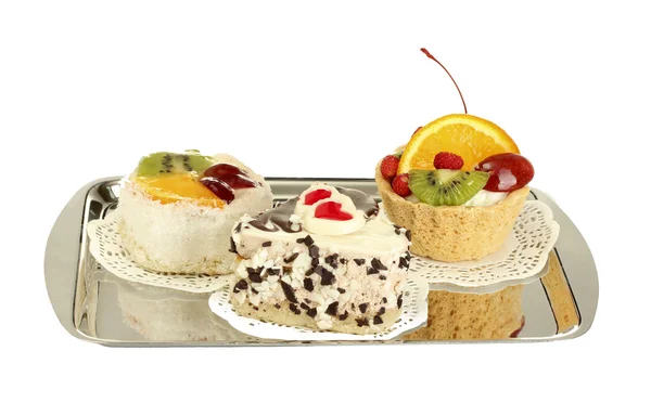 Tortas dulces con frutas y chocolate en bandeja de plata aislada en blanco — Foto de Stock