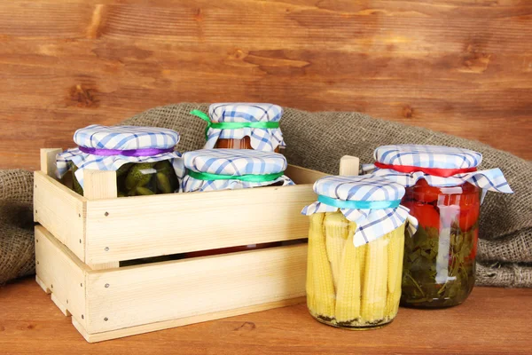 Frascos con verduras enlatadas sobre fondo de madera de cerca —  Fotos de Stock