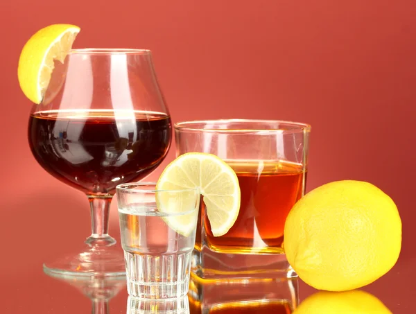 Una variedad de bebidas alcohólicas sobre fondo rojo —  Fotos de Stock