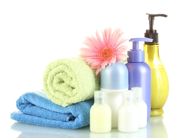 Cosmetics bottles with towels and flower isolated on white — Stock Photo, Image