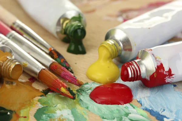 Abstrakt akrylfärg, måla rören och penslar på trä palett — Stockfoto