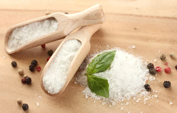 Sůl s čerstvou bazalkou a a pepř na dřevěný stůl — Stock fotografie