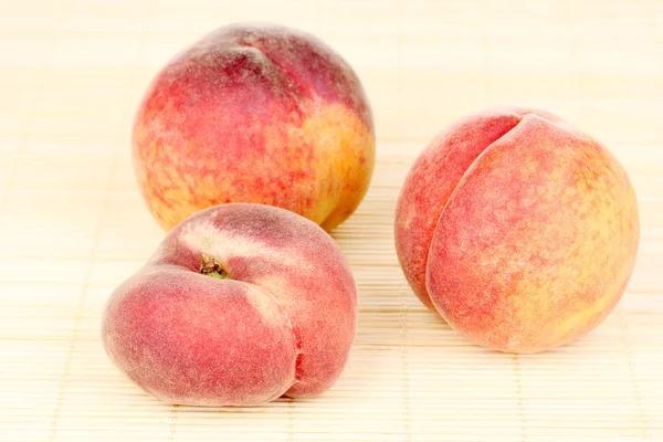 Ripe peaches on bamboo mat — Stock Photo, Image