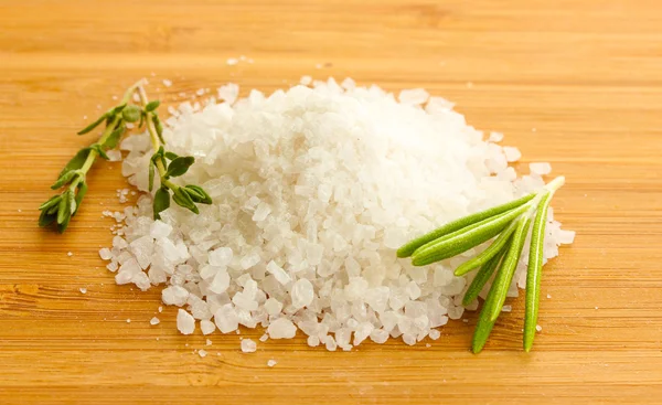 Соль со свежим розмарином и тимьяном на деревянном фоне — стоковое фото