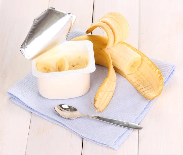 Yoghurt med banan på trä bakgrund — Stockfoto