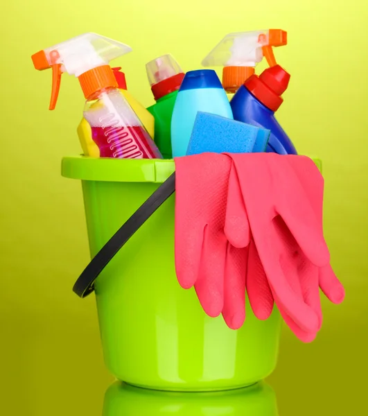 Cubo con artículos de limpieza sobre fondo verde — Foto de Stock