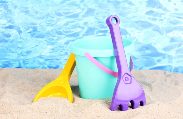 水の背景に砂の上の子供のビーチおもちゃ — ストック写真
