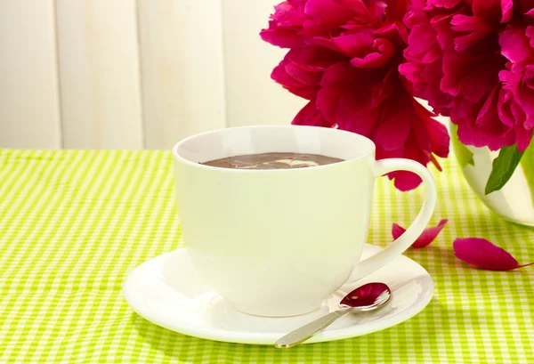 Taza de chocolate caliente y flores en la mesa en la cafetería —  Fotos de Stock