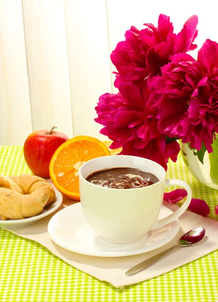 Cup hot chocolate, apple, orange, cookies and flowers on table in cafe — Stock Photo, Image