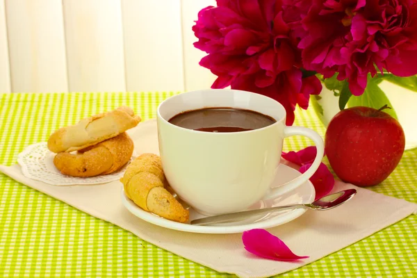 Kopp varm choklad, äpple, cookies och blommor på bord i café — Stockfoto