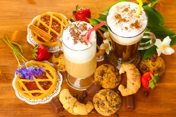 Glasses of coffee cocktail on wooden table with sweet and flowers — Stock Photo, Image