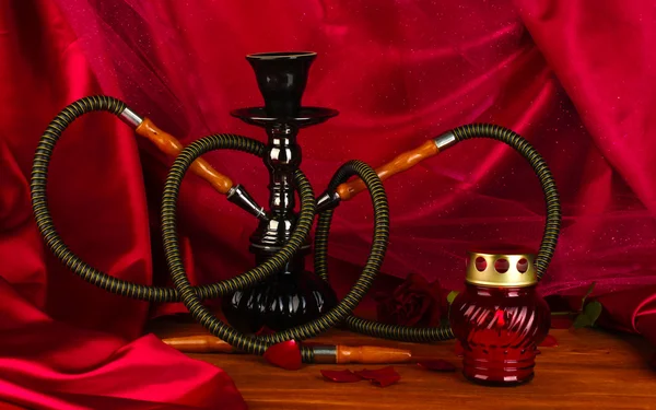 Hookah on a wooden table on a background of red curtain close-up — Stock Photo, Image