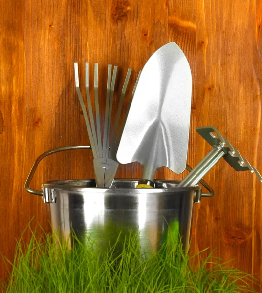 Garden tools on grass on wooden background close-up — Stock Photo, Image