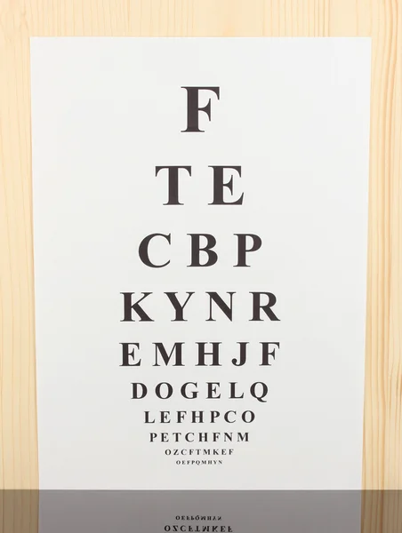 Eyesight test chart on wooden background — Stock Photo, Image