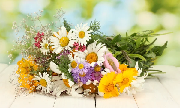 Belo buquê de flores silvestres brilhantes, na mesa de madeira no fundo verde — Fotografia de Stock