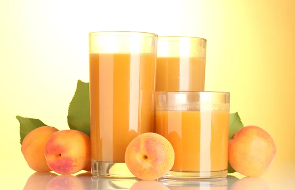 Glasögon av aprikos juice på gul bakgrund — Stockfoto