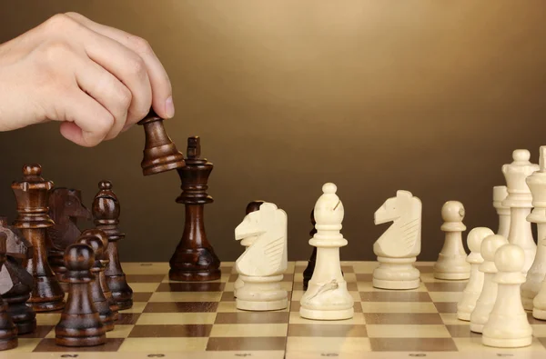 Schaakbord met schaakstukken op bruine achtergrond — Stockfoto