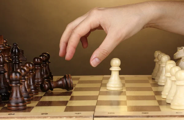 Tablero de ajedrez con piezas de ajedrez sobre fondo marrón —  Fotos de Stock