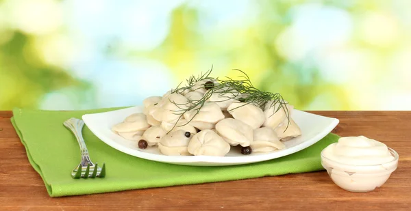 Köstlich gekochte Knödel im Gericht auf leuchtend grünem Hintergrund — Stockfoto