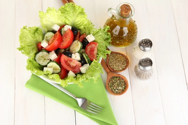 Leckerer griechischer Salat mit Gewürzen auf weißem Holzhintergrund — Stockfoto