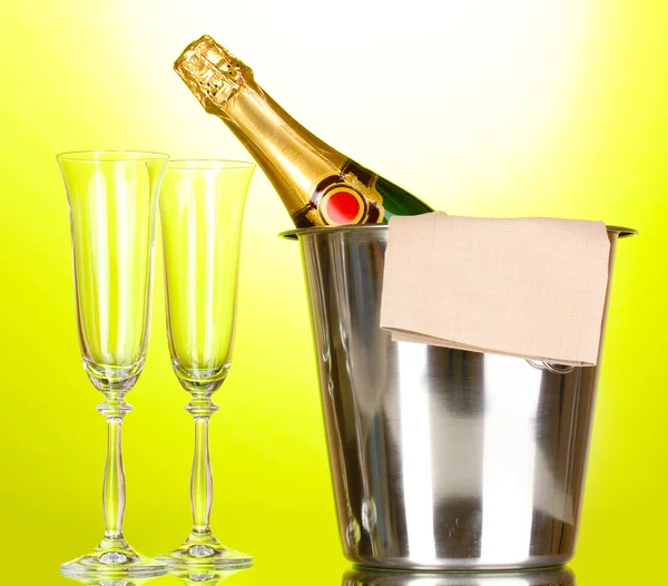 Botella de champán en cubo con hielo y copas sobre fondo verde —  Fotos de Stock