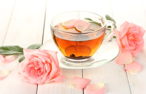 Kopje thee met rozen op witte houten tafel — Stockfoto