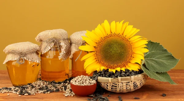 Zonnebloemolie en zonnebloem op gele achtergrond — Stockfoto