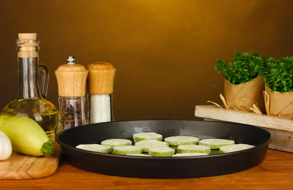Gesneden pompoen in een pan op houten tafel op browm achtergrond close-up — Stockfoto