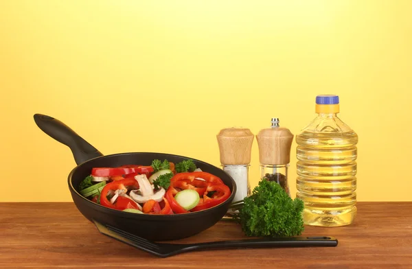 Koekenpan met groenten op gele achtergrond — Stockfoto