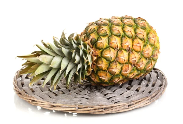 Ananas na maty wiklinowe na białym tle — Zdjęcie stockowe
