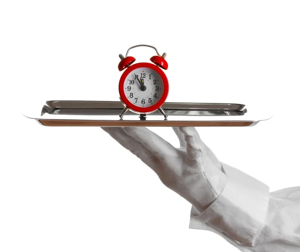 Χέρι-γάντι, κρατώντας το ασημένιο δίσκο με το ρολόι συναγερμών που απομονώνονται σε λευκό — Φωτογραφία Αρχείου