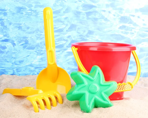 Zabawki dla dzieci plaży na piasku na tle wody — Zdjęcie stockowe