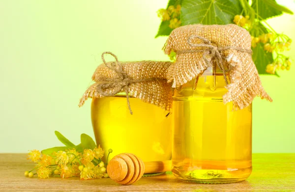 シナノキの蜂蜜と緑の背景に木製のテーブルの花瓶 — ストック写真