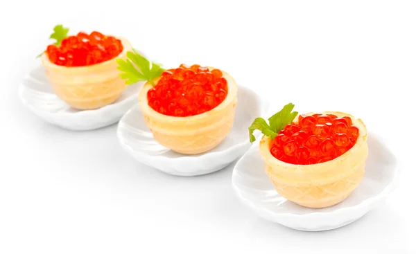 Roter Kaviar in Törtchen auf kleinen weißen Untertassen isoliert auf weißen — Stockfoto