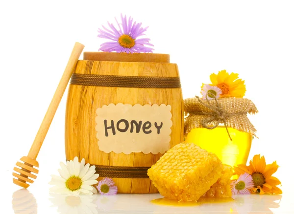 Miel dulce en tarro y barril con panal, rociador de madera y flores aisladas en blanco —  Fotos de Stock