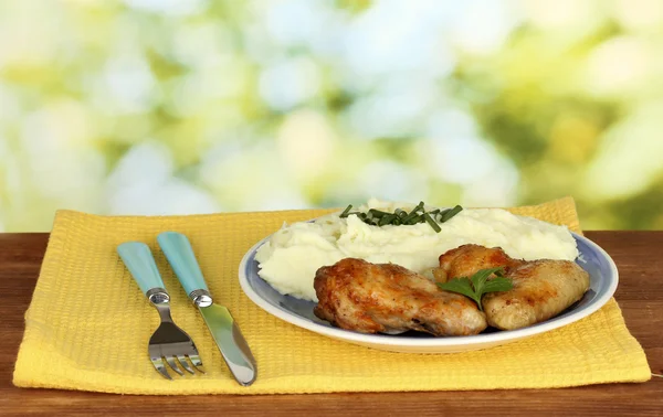 Coscia di pollo arrosto con purè di patate nel piatto su tavolo di legno su sfondo luminoso primo piano — Foto Stock