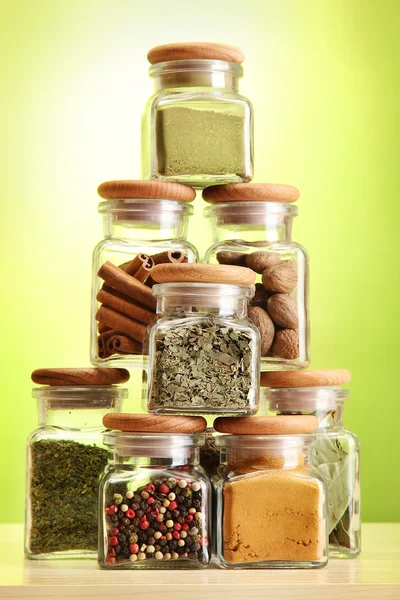 Poeder specerijen in glazen potten op groene achtergrond — Stockfoto