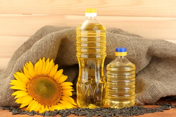 Sunflower oil and sunflower on wood background — Stock Photo, Image